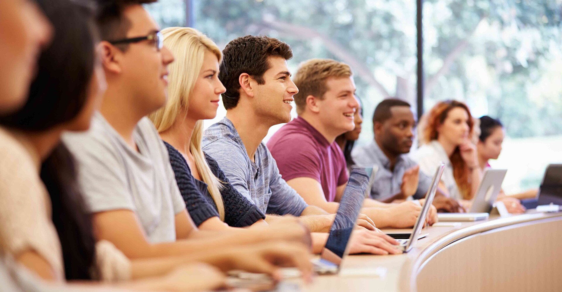 Studierende sitzen mit Laptop im Vorlesungssaal.