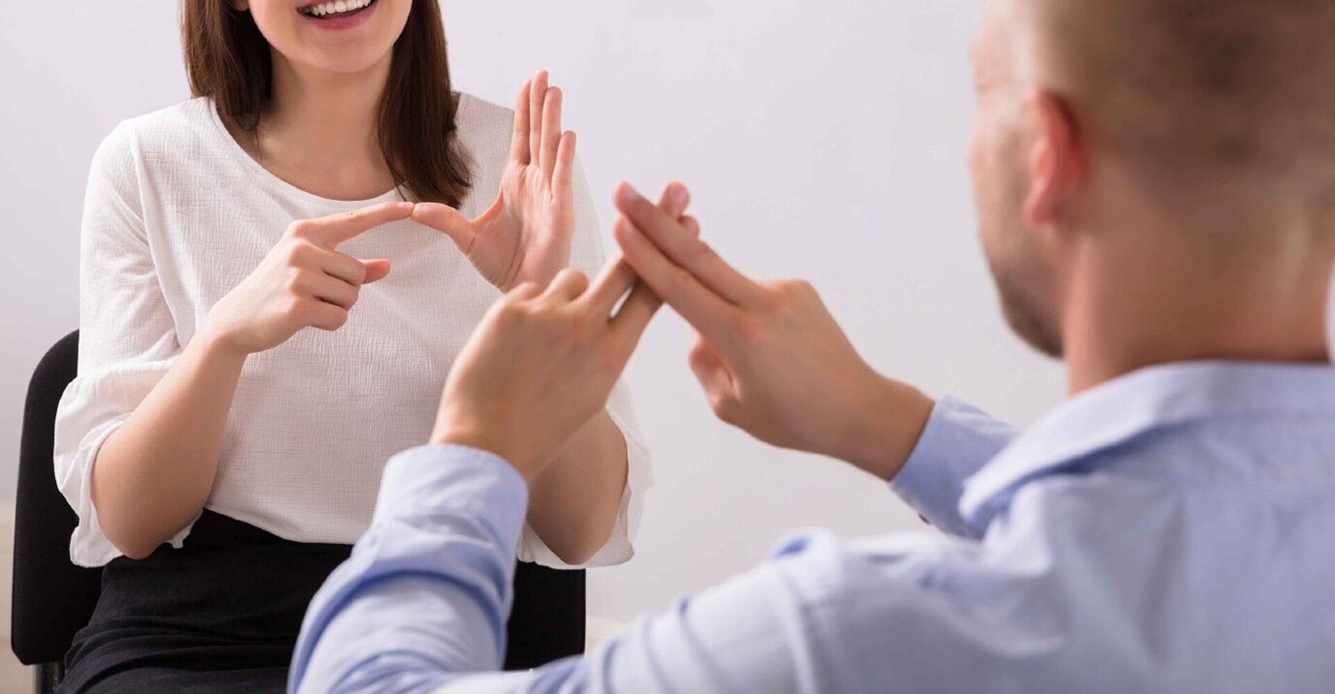 Zwei Personen sprechen in Gebärdensprache miteinander.