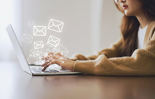 Frau schreibt Email am Laptop.