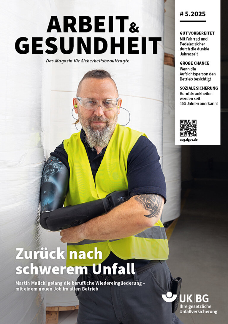 Titelbild Arbeit und Gesundheit. Mann lehnt mit Arbeitsweste bekleidet an einer Wand und schaut in die Kamera. Portraitaufnahme.