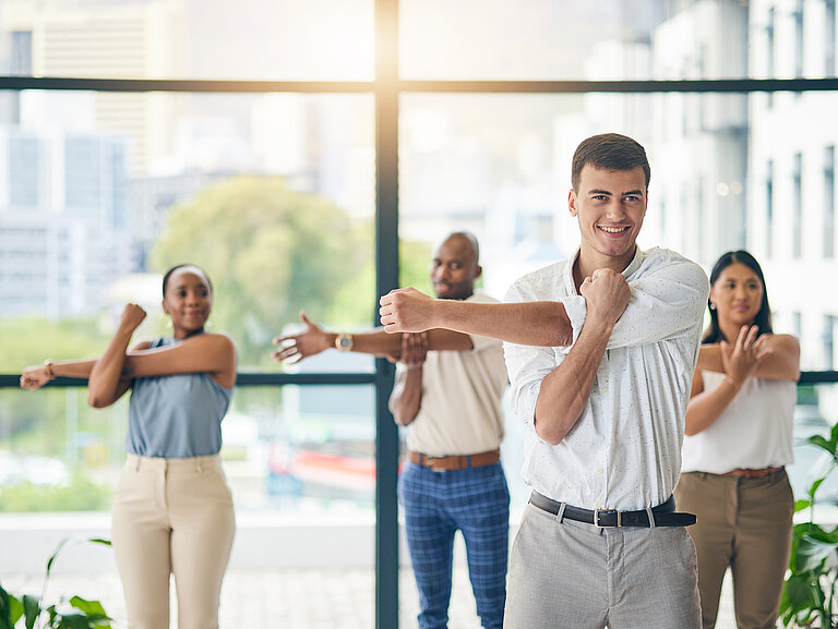 Mehrere Personen dehnen und strecken sich zur Gesundheitsförderung.