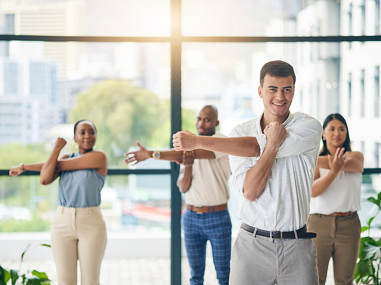 Mehrere Personen dehnen und strecken sich zur Gesundheitsförderung.