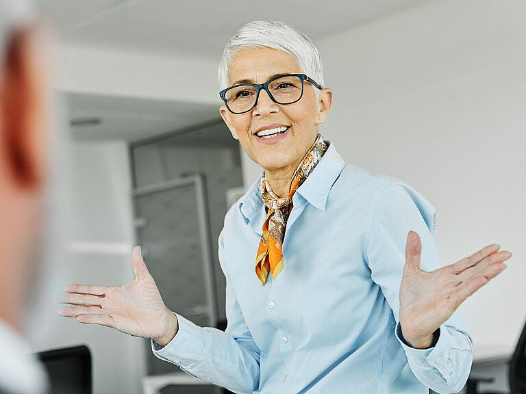 Eine kurzhaarige Geschäftsfrau agiert in einem Meeting.