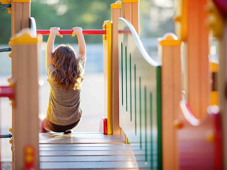 Ein Mädchen klettert auf einem Kletterturm.
